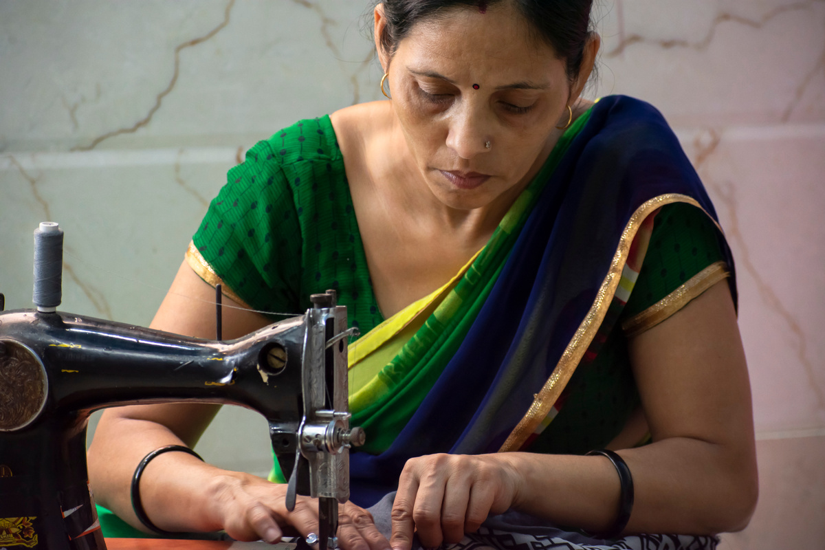 Indian women  stitching cloths by machine at home